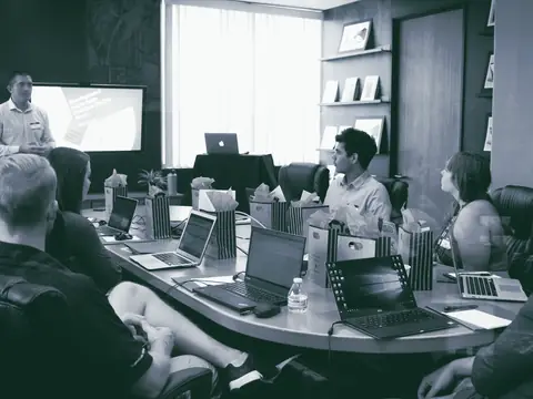 A presenter leading a small group working on laptops